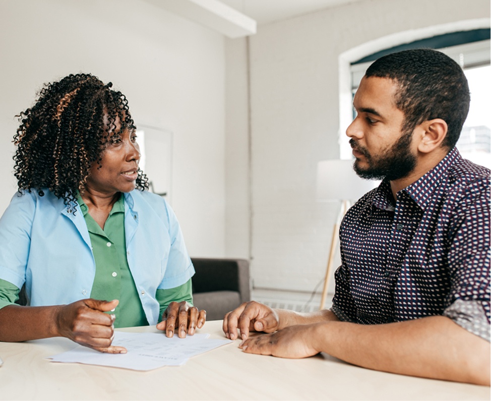 Personal assistant reviewing paperwork at a table with a care coordinator
